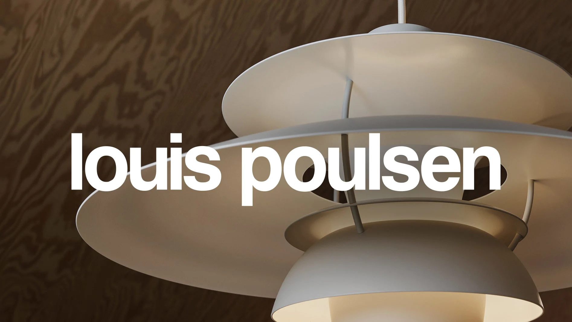 Vit skiktad taklampa med texten 'louis poulsen' i vitt framför en träbakgrund.