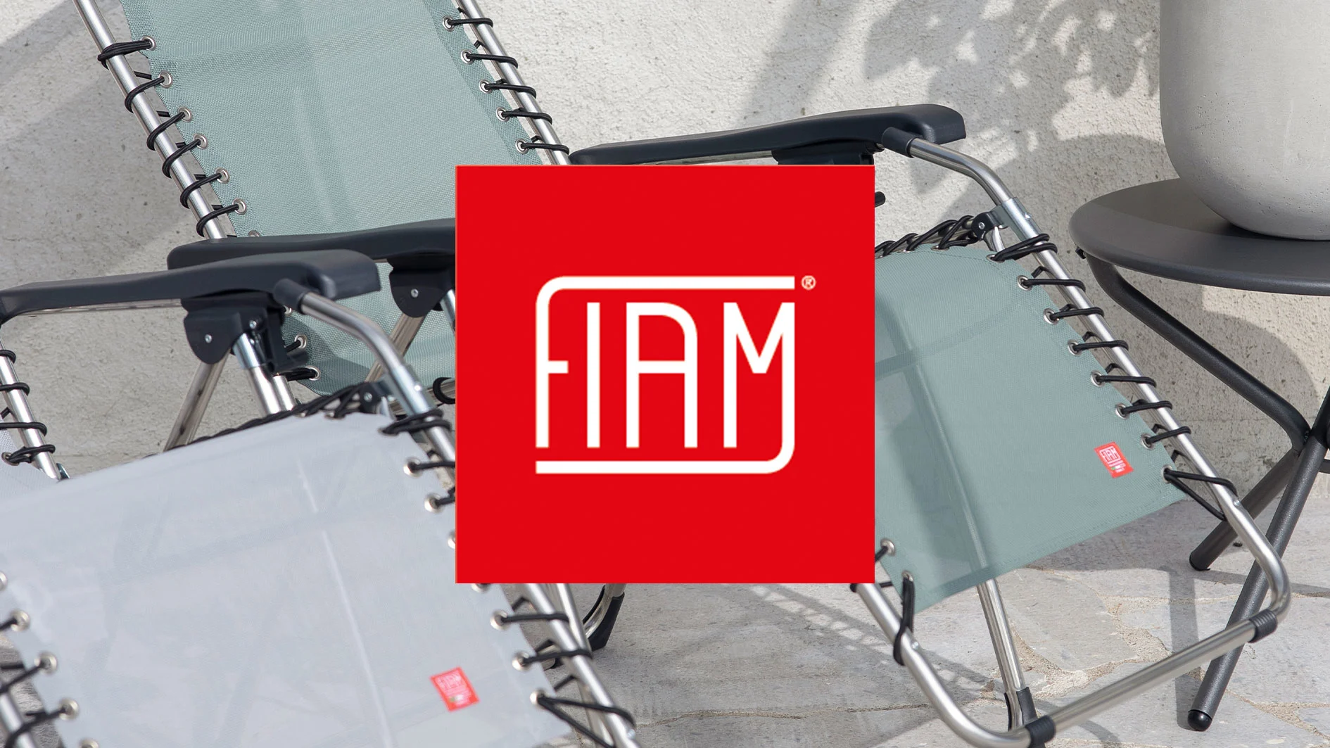 FIAM-logotyp över två utomhusfåtöljer i ljusgrönt och grått, med ett runt bord och en kruka.
