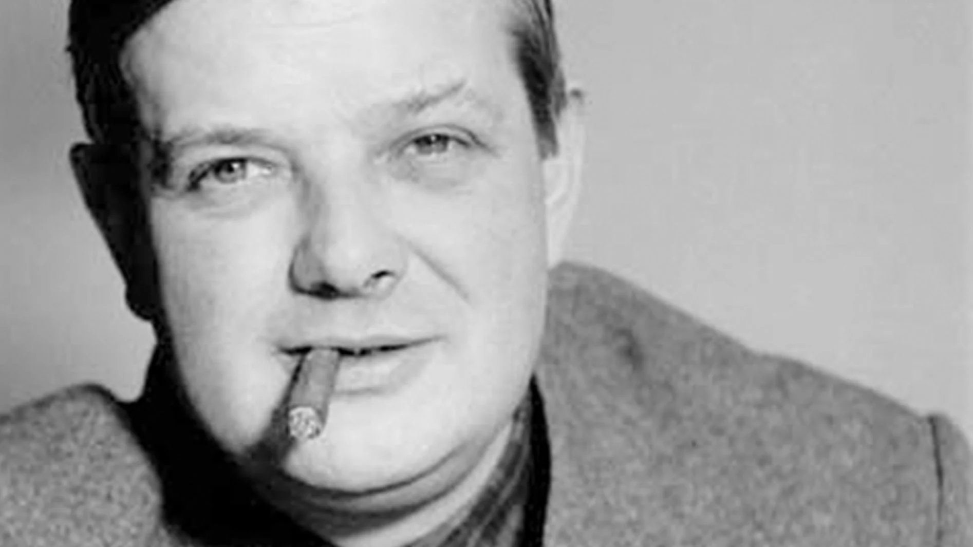 Man med cigarr i munnen, tittar in i kameran i svartvitt.