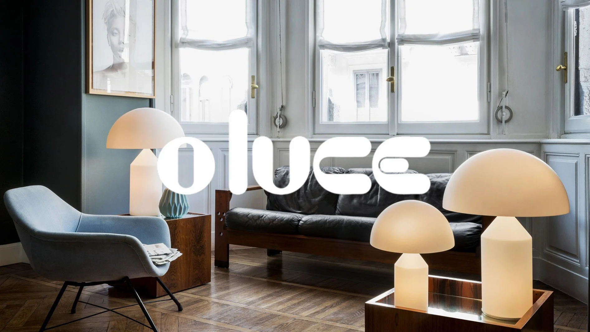 Ett vardagsrum med ljusblå fåtölj, svart skinnsoffa och flera glödande svampformade lampor. "olucc"-logotypen är överlagrad.
