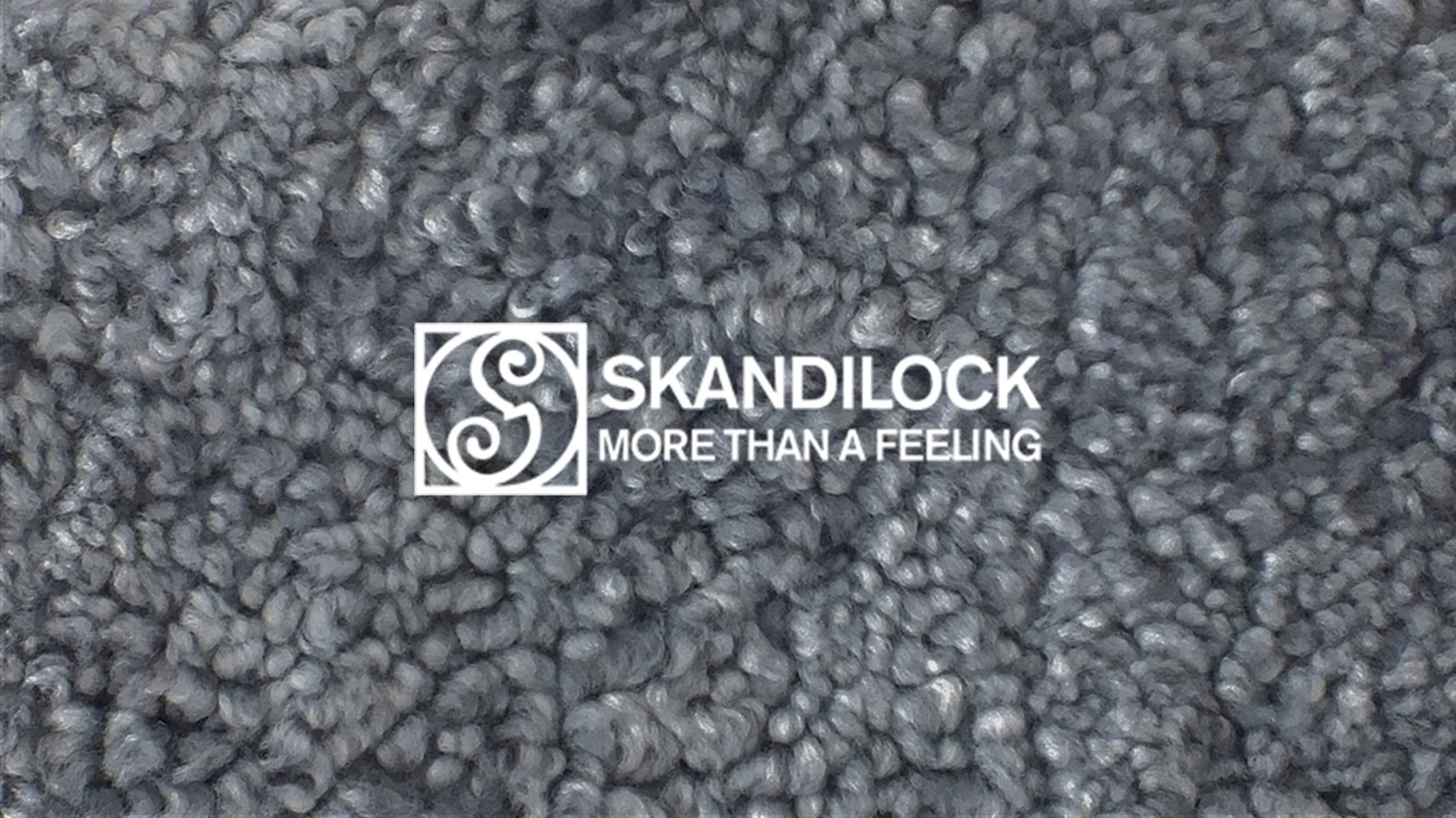 Närbild på grå lockig fårskinnsstruktur med Skandilock-logotyp och 'More Than A Feeling' text i vitt.
