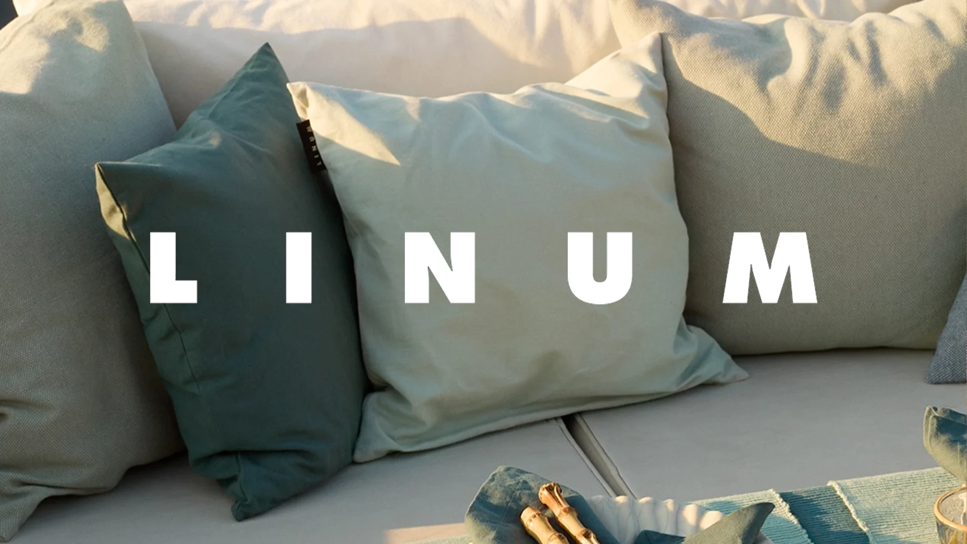 Prydnadskuddar i grönt och beige på en soffa, med texten "LINUM" över bilden.