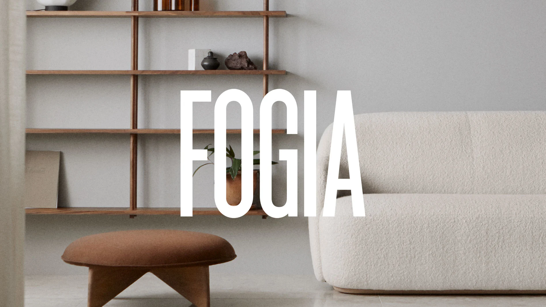 FOGIA-logotyp över en minimalistisk interiör med en krämfärgad soffa, brun fotpall och en hylla.