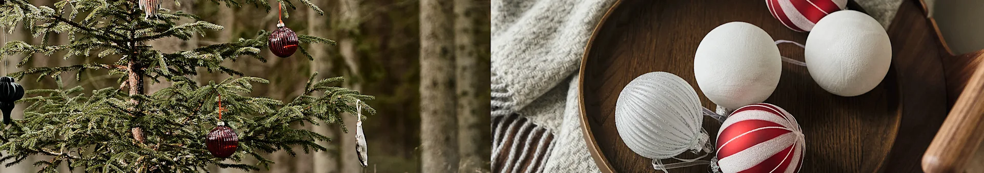 Julgransgrenar med röda och silverfärgade ornament, bredvid en träskål med vita, silver och rödrandiga julkulor.
