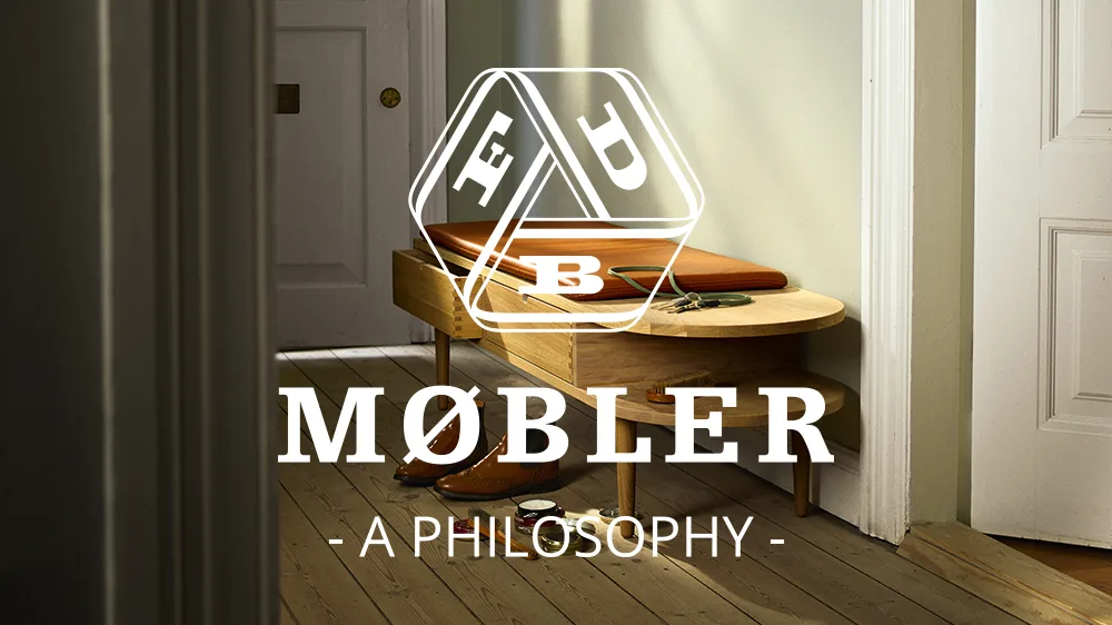 Hall med träbänk med brun läderkudde, bruna finskor och skovård. Text: MØBLER - A PHILOSOPHY -.